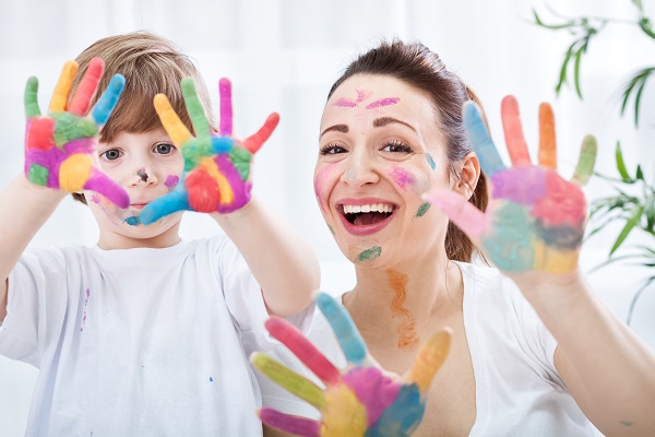 Mother and child holding painted hands up